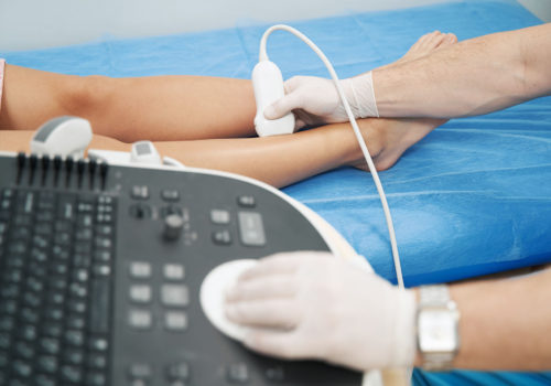 Doctor specialist checking the veins in the patient legs with an ultrasound machine